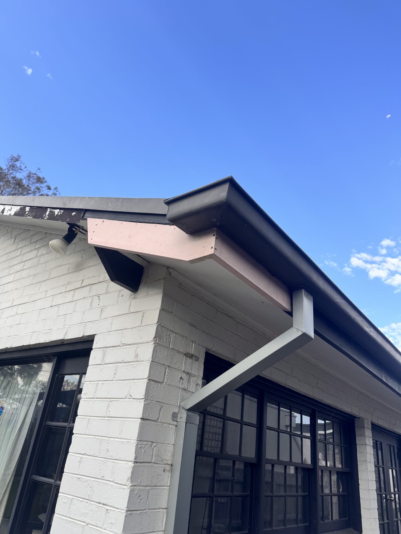After: new fascia timber installed at the same corner, still primed